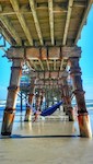Gal enjoys shade under Sunglow Pier in her hammock on World's Most Famours Beach in Daytona, FL / Headline Surfer
