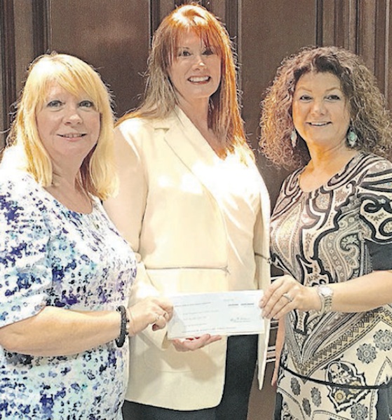 Daytona Beach City Commissioner Pam Woods poses with Cytnhia Politis Bank of America marketing president Cynthia Politix, in handing over a $5,000 check to Forough Hosseini for her Food Brings Hope weekend feeding care bag that feeds 200 families / Headline Surfer
