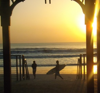 Surfer with board on New Smyrna Beach at sunrise Monday / Headline Surfer