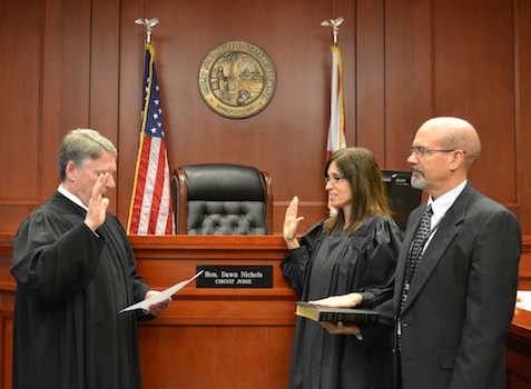 Dawn Nichols sworn in as circuit judge by Chief Judge Terence Perkins an Circuit Judge Jim Clayton holding bivble / Headline Surfer®